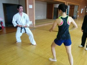 Miyakawa hanshi demonstrating center of mass transmission with seminar participant using a rokushakubo